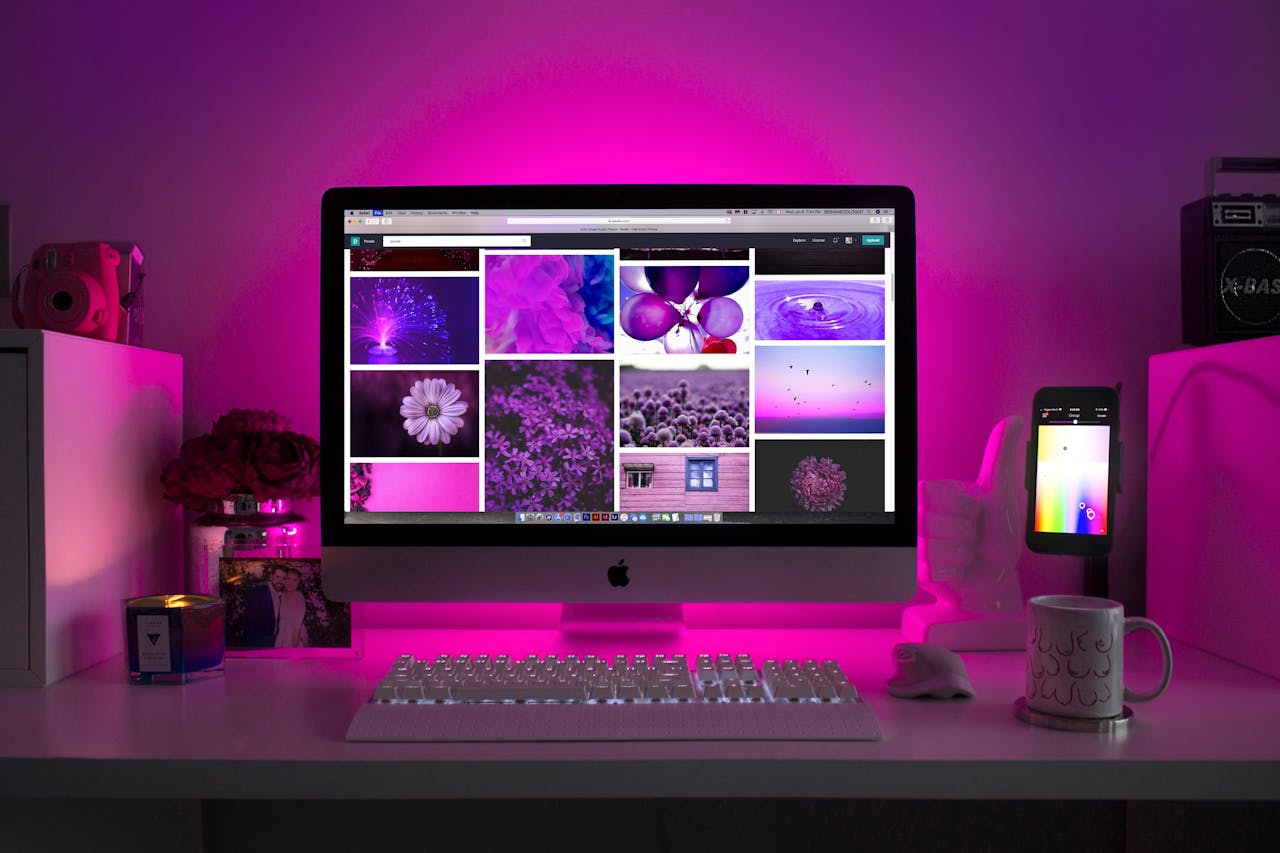 home-hero Modern desk setup with neon lighting and a desktop computer displaying colorful images.